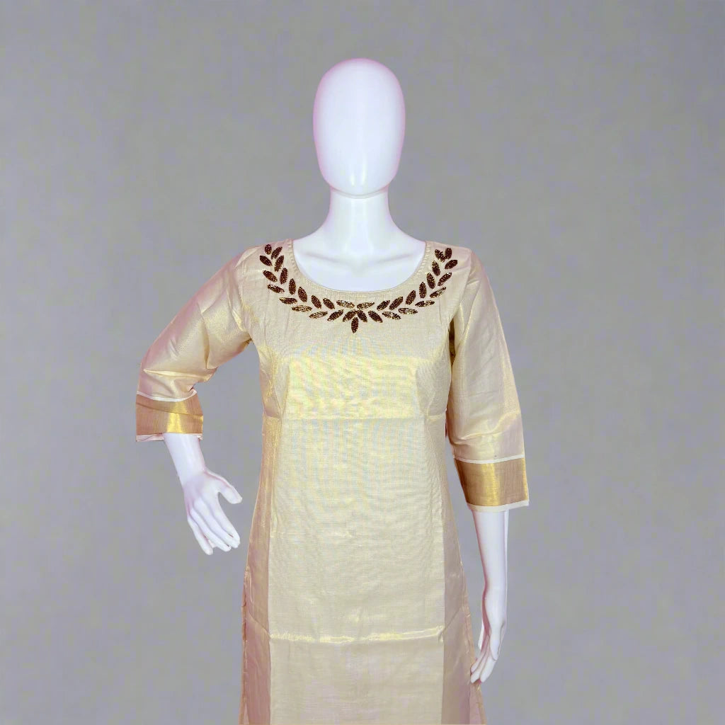 Mannequin wearing a cream-colored dress with gold accents on a gray background