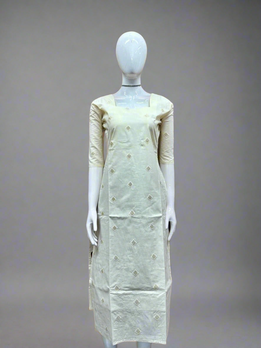 Mannequin wearing a light green dress with floral patterns against a geometric patterned wall.