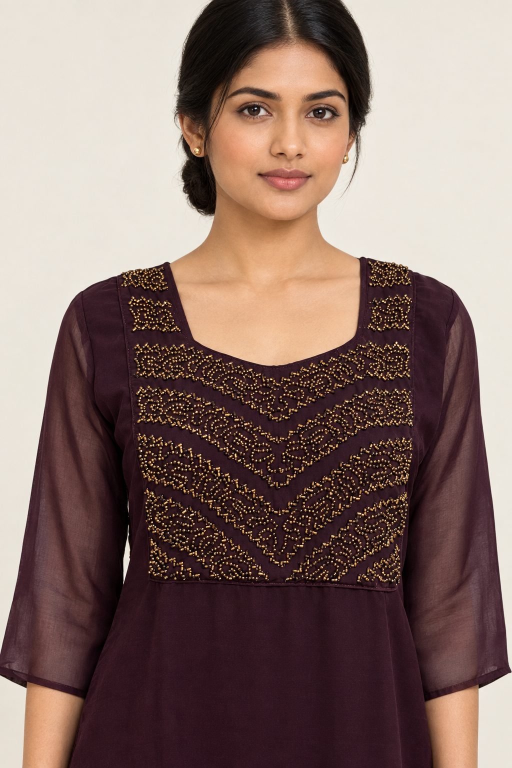 Close-up of gold-toned yoke embroidery on plum kurta