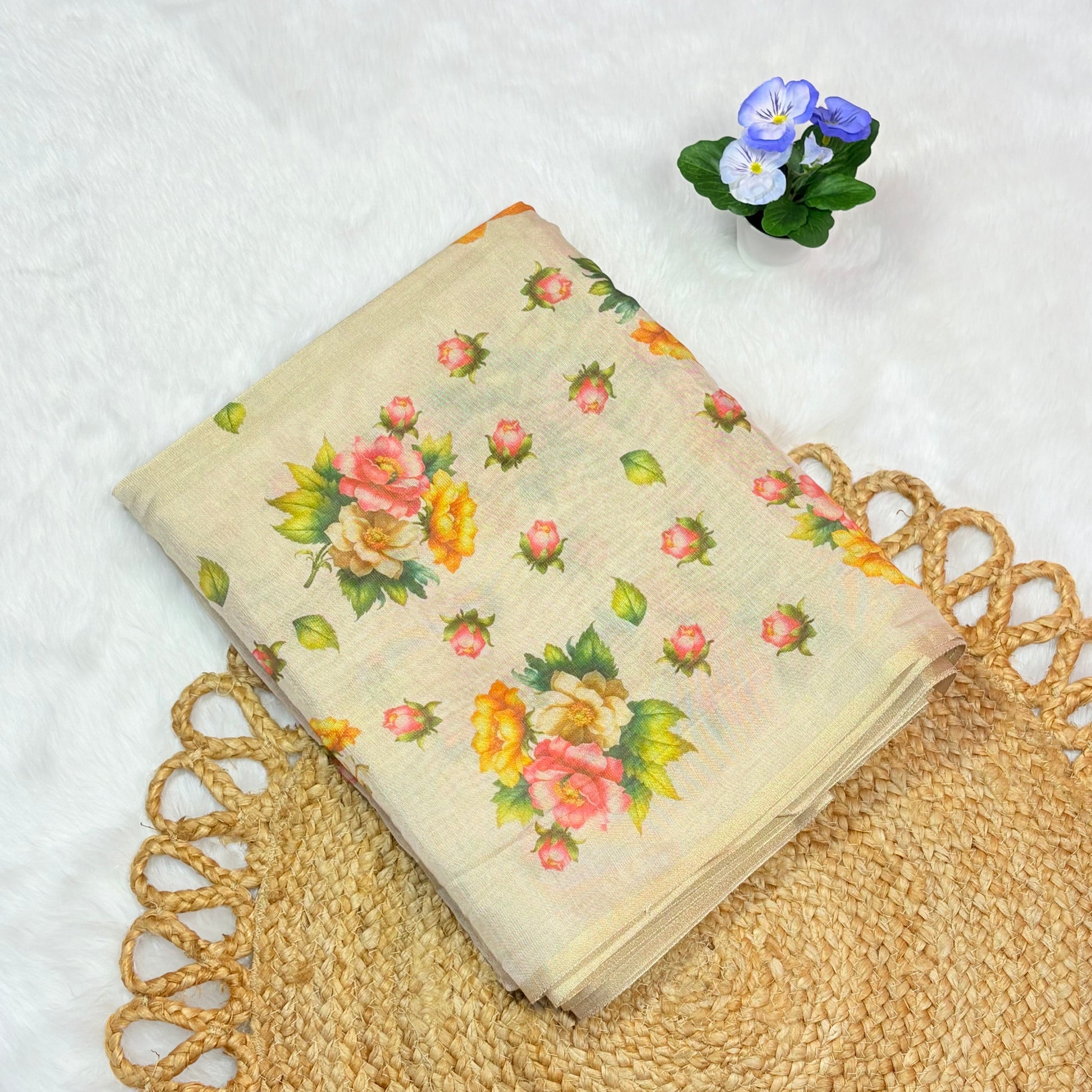 Floral-patterned fabric on a textured surface with a small plant in the corner