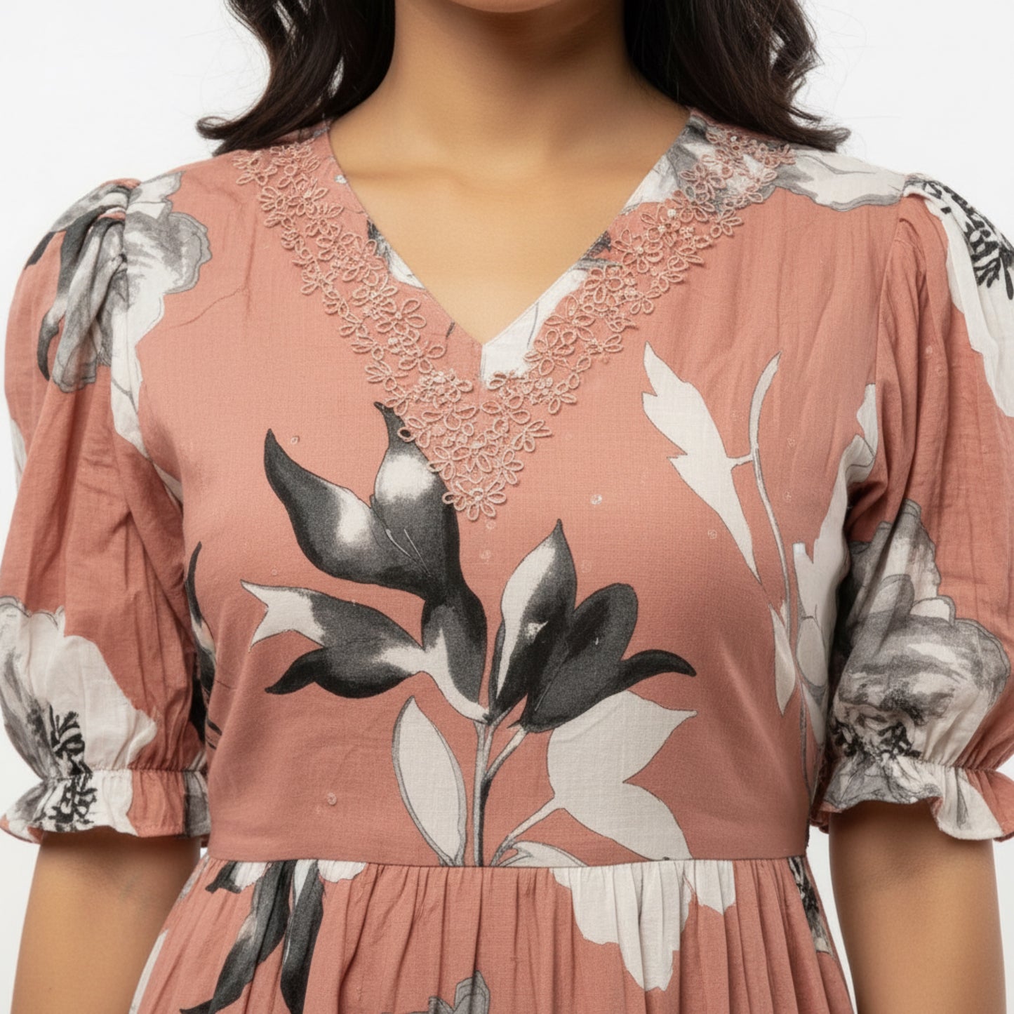 Pink floral dress with intricate details on a plain background