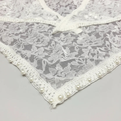 Lace fabric with pearl embellishments on a gray background
