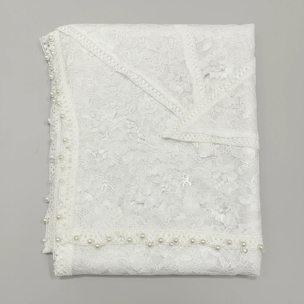 White lace fabric with pearl embellishments on a gray background