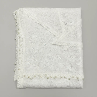 White lace fabric with pearl embellishments on a gray background