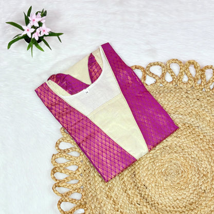 Purple and beige blouse on a textured surface with flowers in the corner