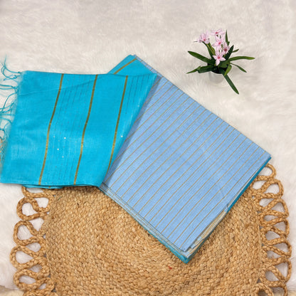 Aqua blue Bapta Tussar silk saree with woven zari lines, subtle sequin accents, tasselled pallu, and matching blouse piece, folded on a natural mat