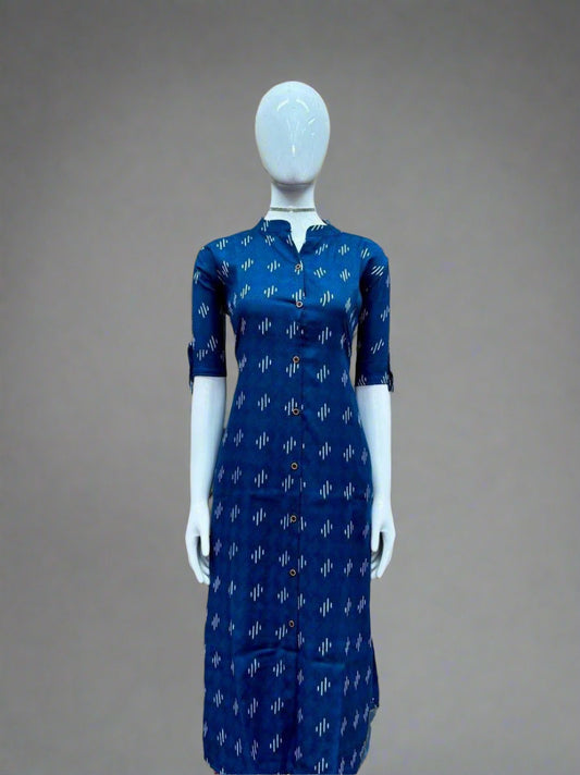 Mannequin wearing a blue dress with white patterns against a geometric patterned wall.