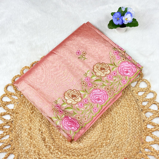 Pink embroidered fabric with floral patterns on a textured surface