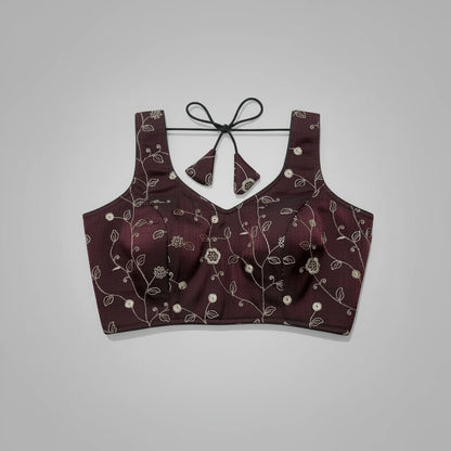 Maroon embroidered lingerie set on a decorative woven mat with a blue background