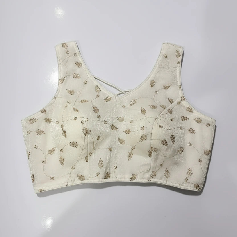 White embroidered top on a woven placemat with a white background