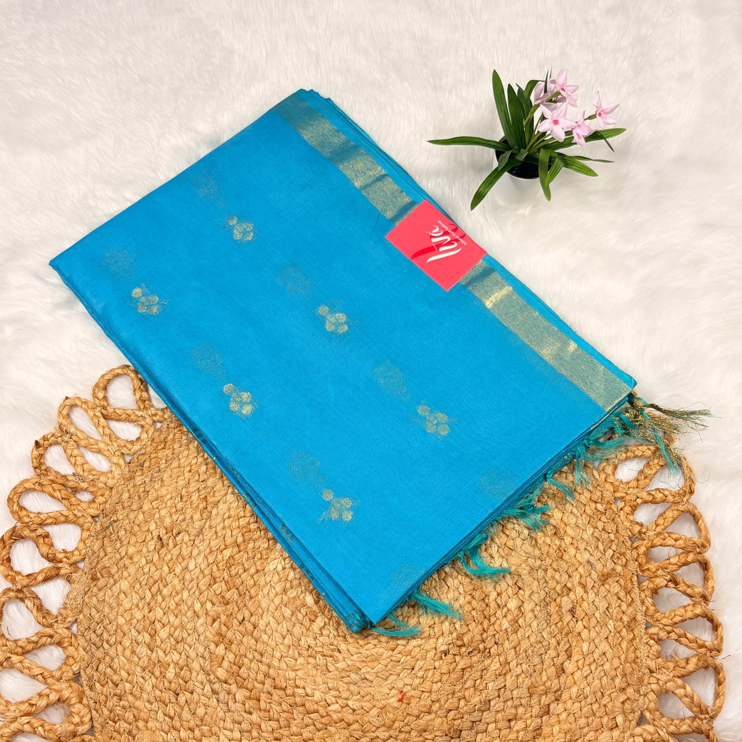 Blue saree with a pink label on a textured surface