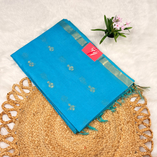 Blue saree with a pink label on a textured surface