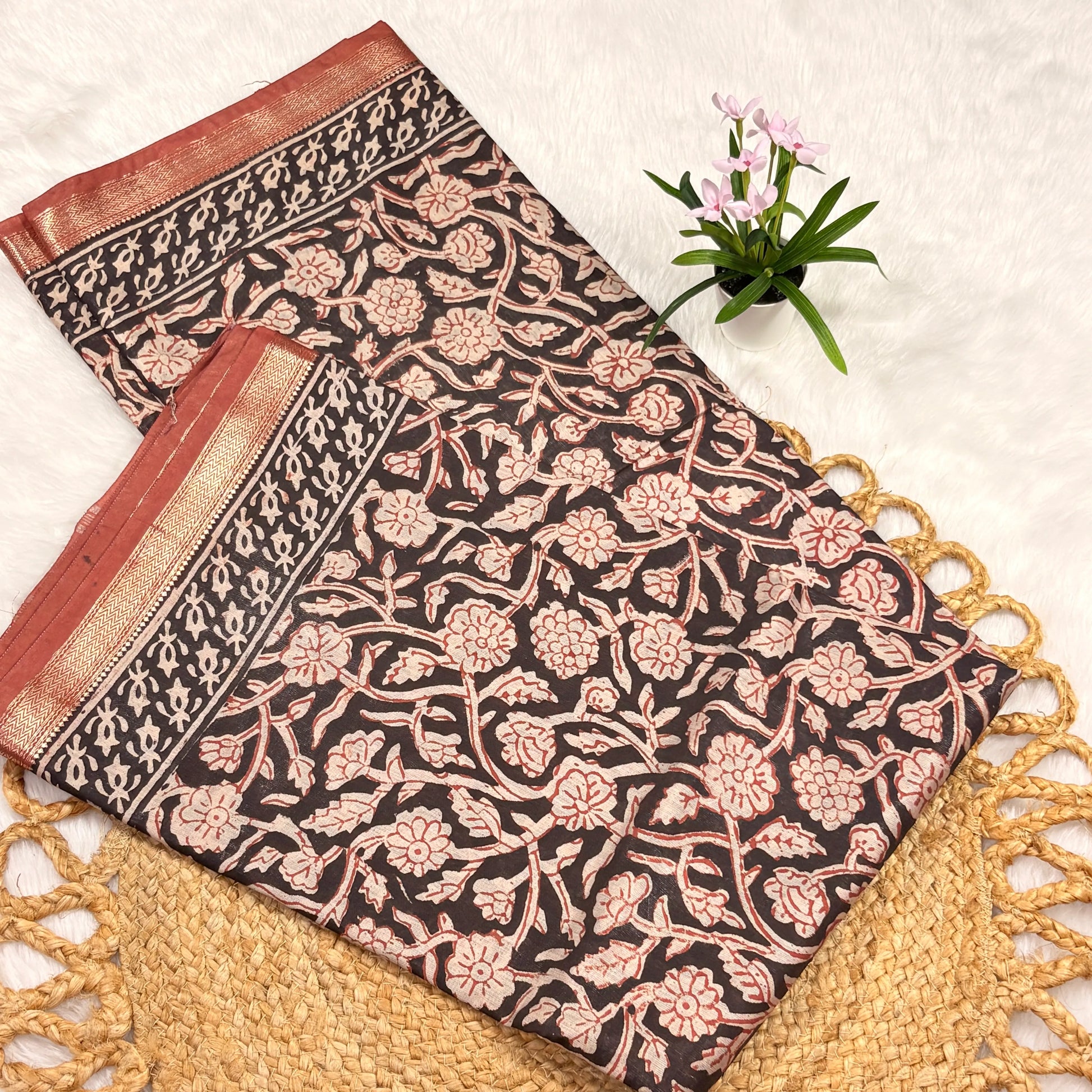 Floral patterned fabric with red and gold accents on a textured surface