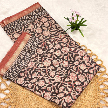 Floral patterned fabric with red and gold accents on a textured surface