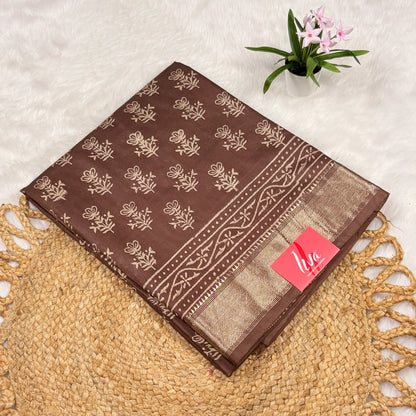 Cocoa‑brown Maheshwari art silk saree with beige floral buta, vine border, soft gold zari panel, and matching blouse piece