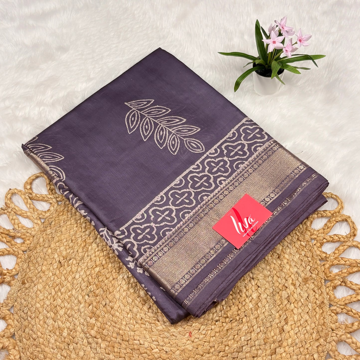 Slate‑purple Maheshwari art silk saree with floral buta, bold leaf pallu motif, trellis borders, soft gold zari band, and matching blouse piece