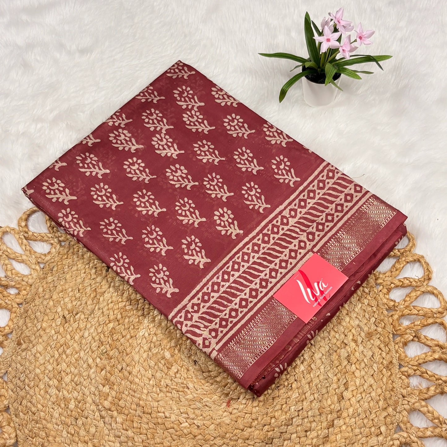 Maroon Maheshwari art silk saree with beige floral buta, geometric vine borders, soft gold zari band, and matching blouse piece