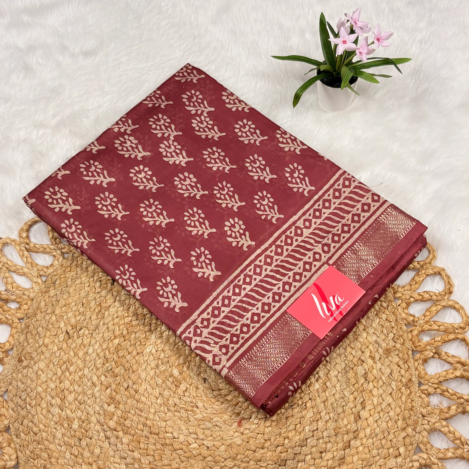 Maroon Maheshwari art silk saree with beige floral buta, geometric vine borders, soft gold zari band, and matching blouse piece