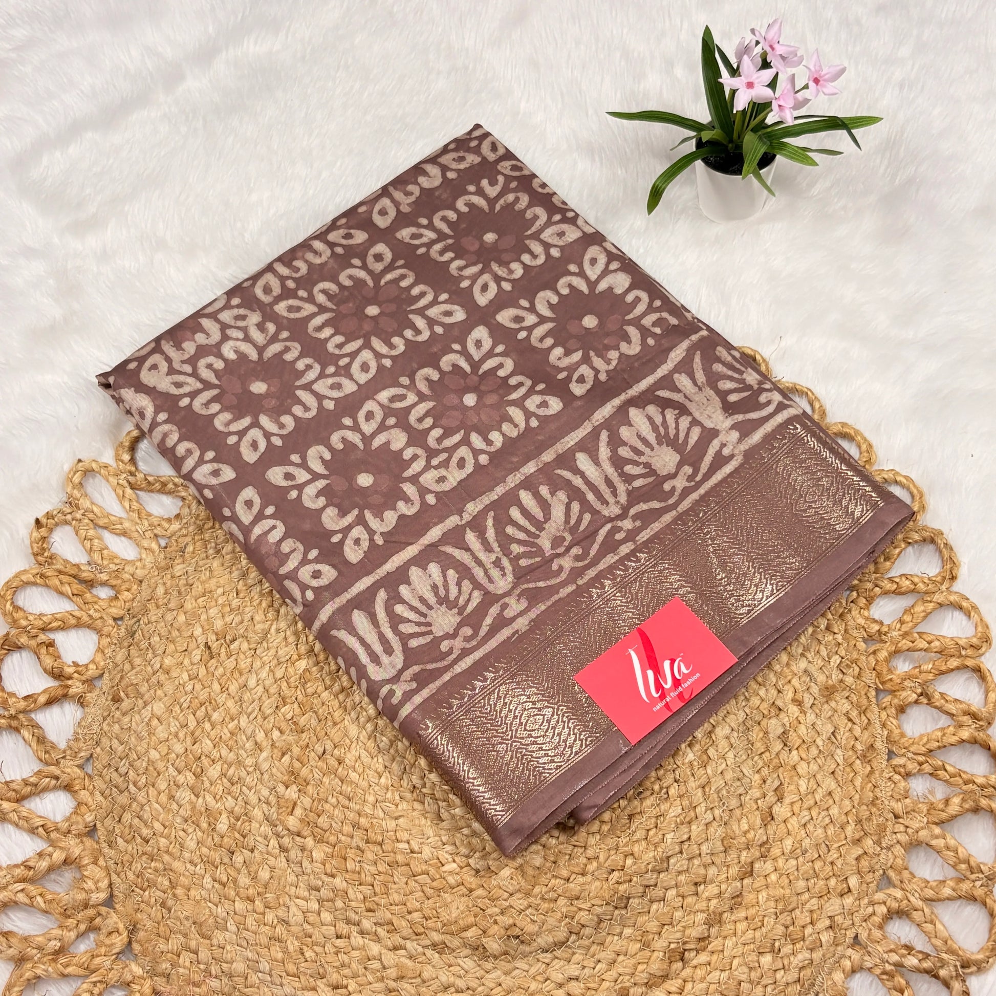 Mauve‑taupe Maheshwari Dabu block print saree with light beige floral blocks, soft gold zari border, tasselled pallu, and matching blouse piece