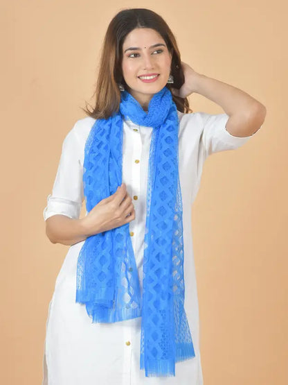 Woman wearing a blue scarf against a beige background