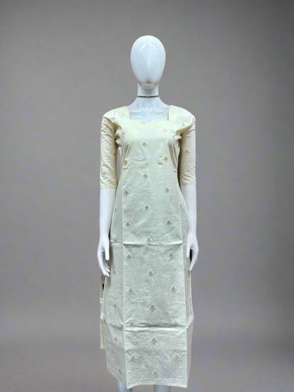 Mannequin wearing a light green dress with floral patterns against a geometric patterned wall.