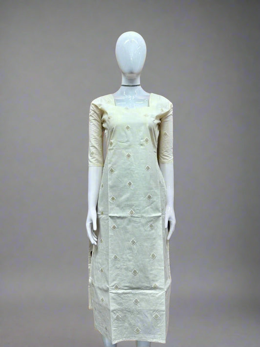 Mannequin wearing a light green dress with floral patterns against a geometric patterned wall.