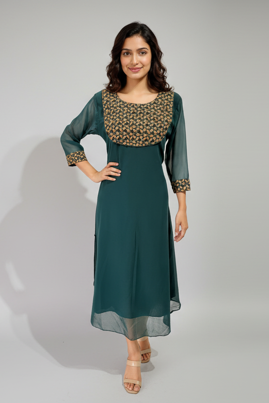 Woman wearing a teal dress with a patterned top against a neutral background