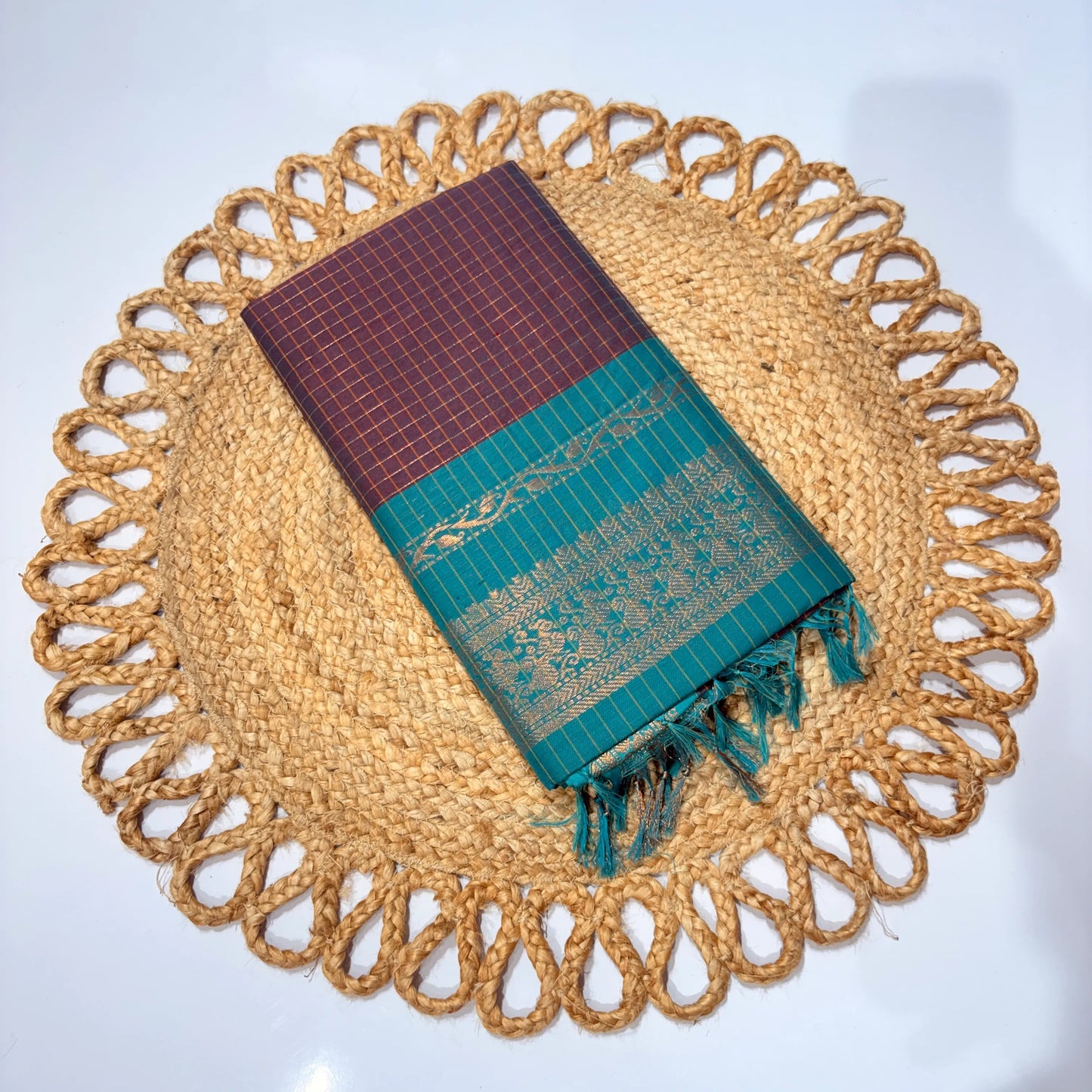Sari on a decorative woven placemat with a white background