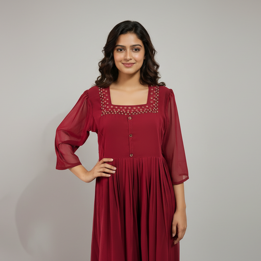 Woman wearing a red dress with a textured neckline against a neutral background