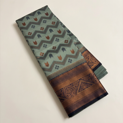 Sage green saree folded display on an off-white background